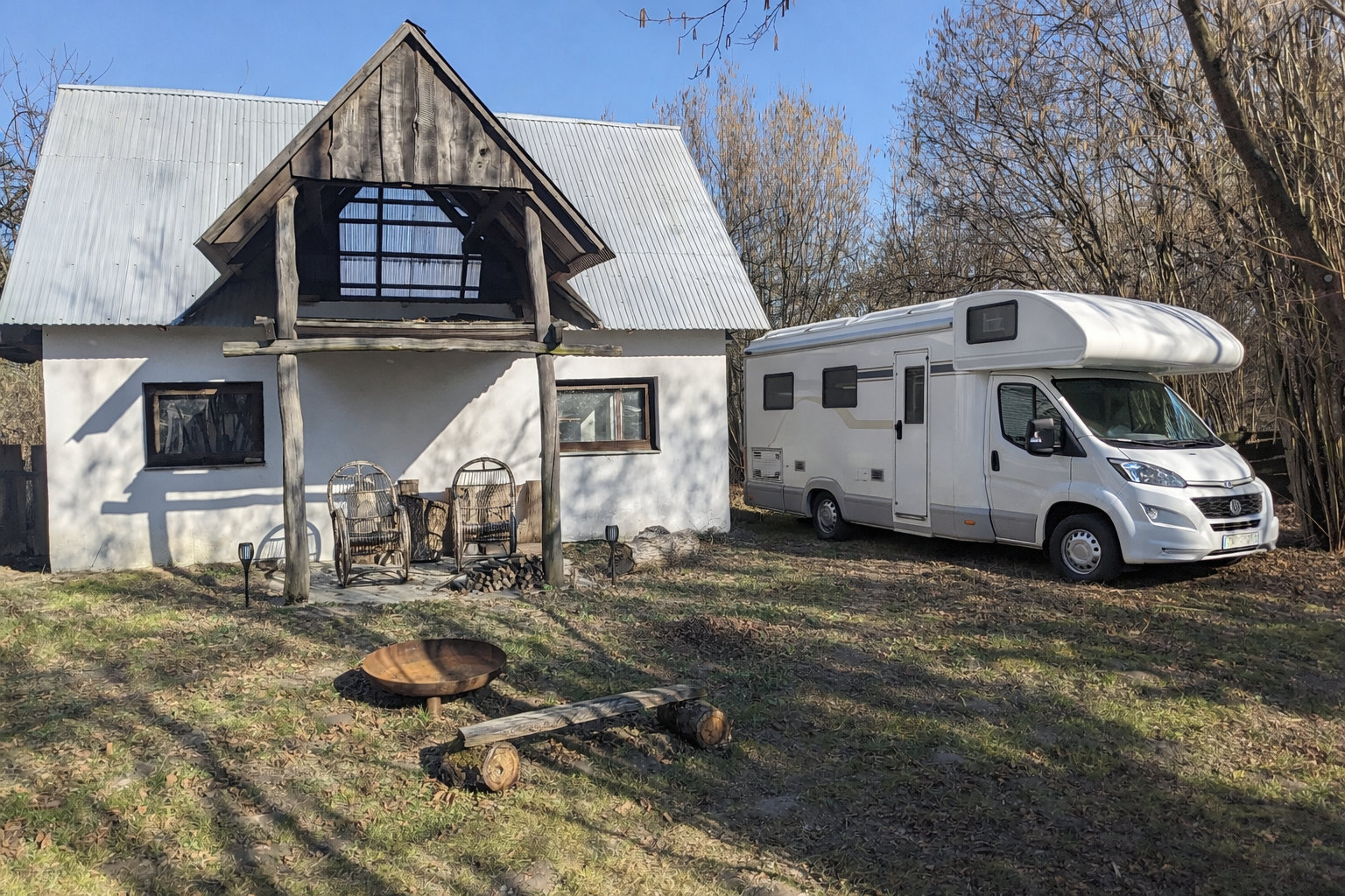 Kamper zaparkowany wśród drzew owocowych w Siedlisku Po Kolei